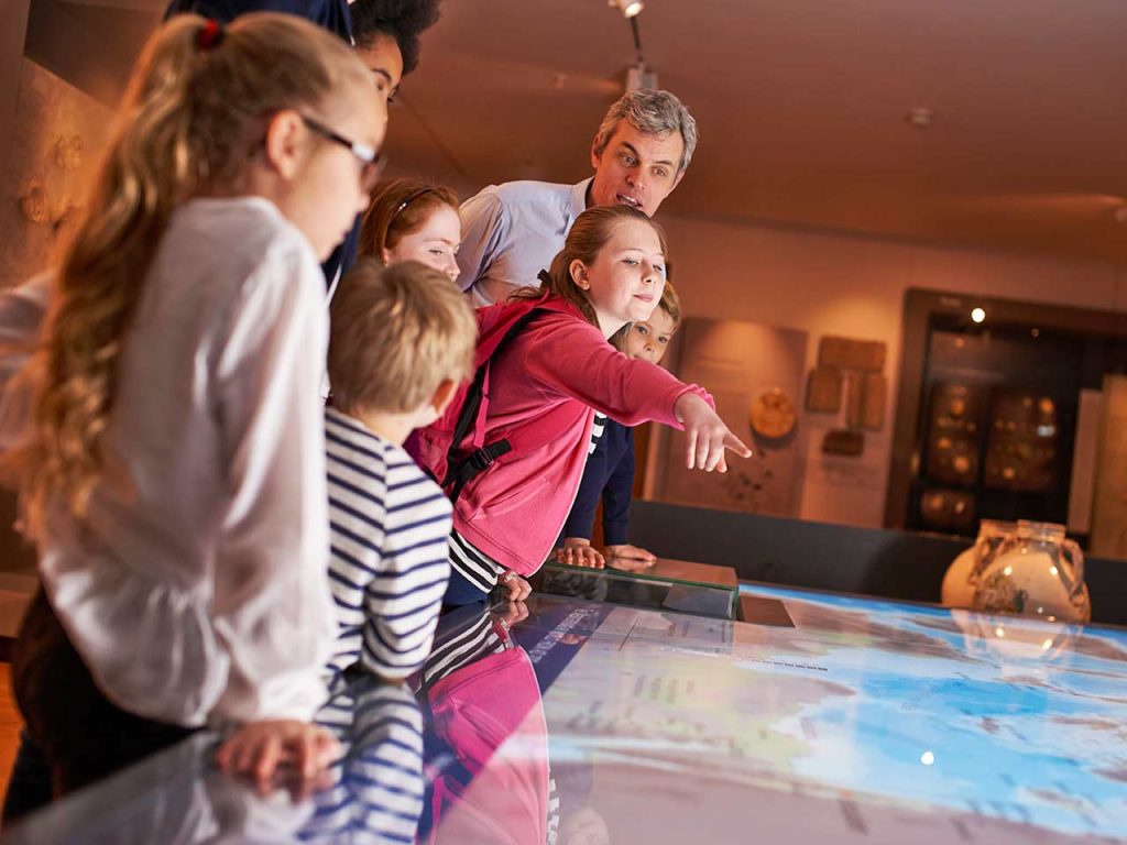 Una famiglia con bambini visita un museo, una delle cose da fare questo inverno in camper suggerite dal PLEINAIRCLUB.