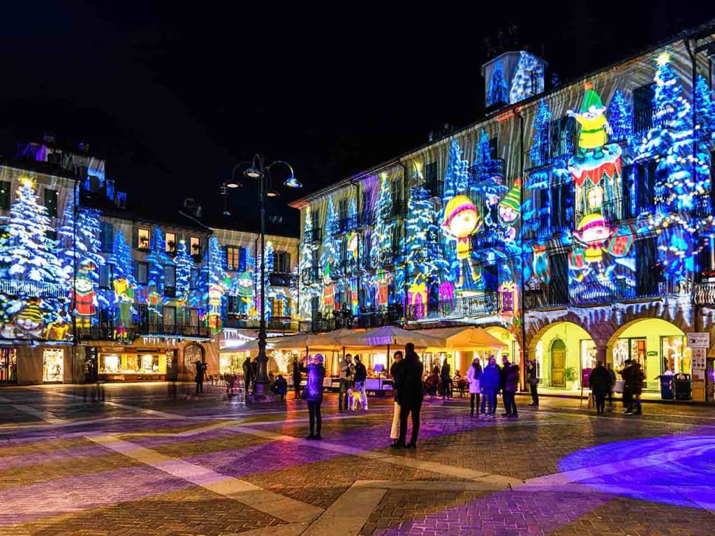 Luci colorate proiettate sui palazzi di Como, una delle tappe dove trascorrere Natale in camper suggerite dal PLEINAIRCLUB.