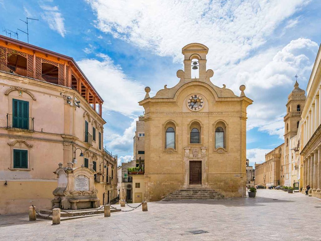 Piazza Notar Domenico a Gravina in Puglia, con Le Quattro Fontane e la Biblioteca Capitolare Filya.