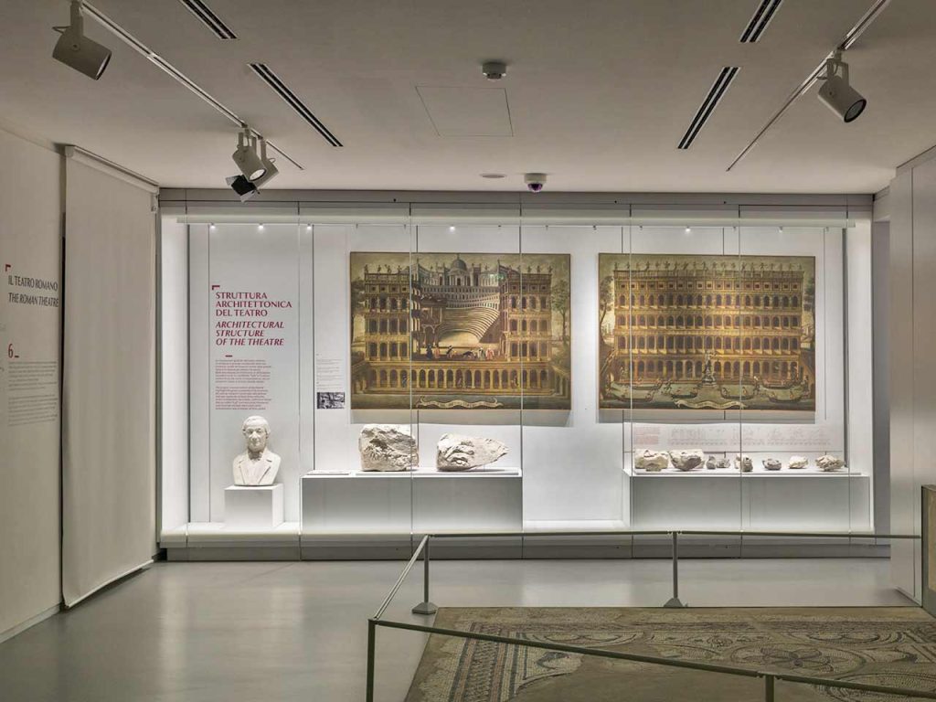 Museo Archeologico al Teatro Romano, Sala degli edifici da spettacolo in epoca romana, Anfiteatro Romano e Teatro, con esposizione di elementi architettonici provenienti dal sito del Teatro.