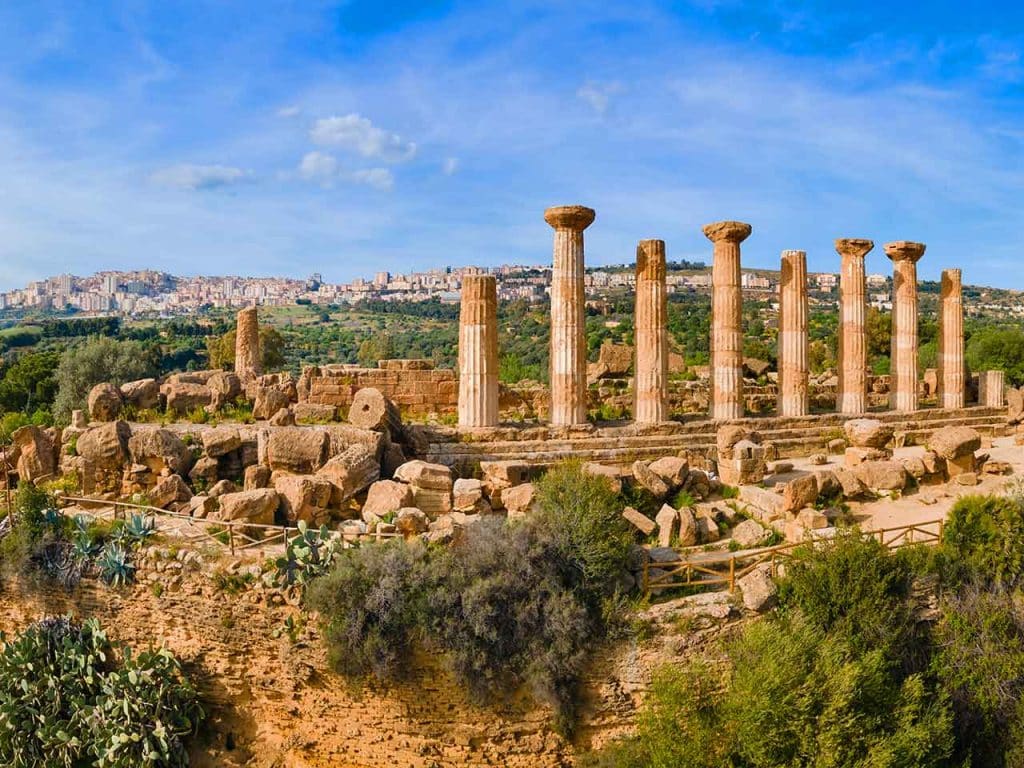 Il Tempio di Ercole nella Valle dei Templi e, sullo sfondo, l'odierna città di Agrigento, uno dei luoghi da visitare in camper a giugno suggeriti dal PLEINAIRCLUB.