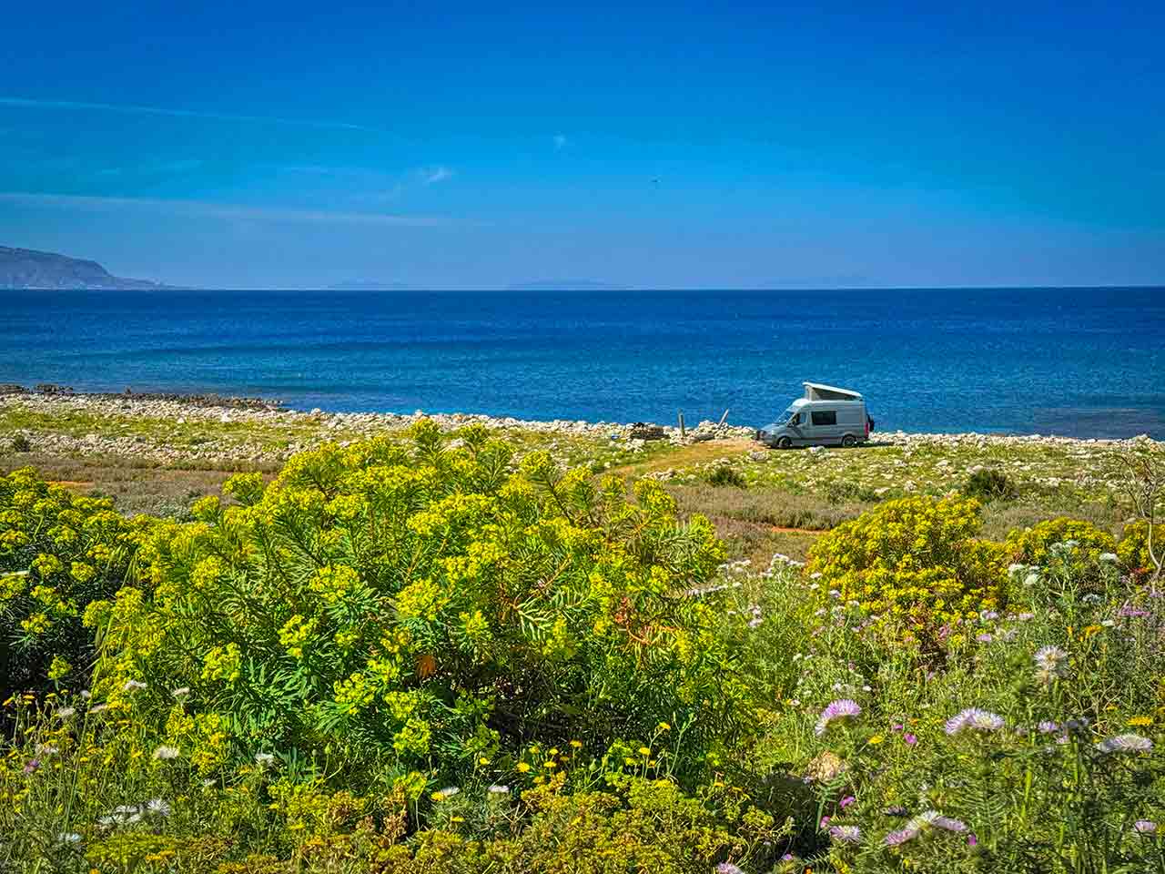 Un van in sosta in una delle aree sosta camper in Sicilia suggerite dal PLEINAIRCLUB.